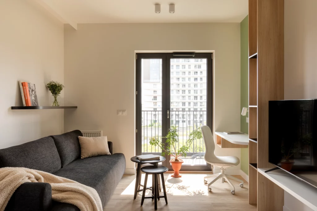 Salon z dostępem do balkonu w apartamencie na wynajem blisko centrum.