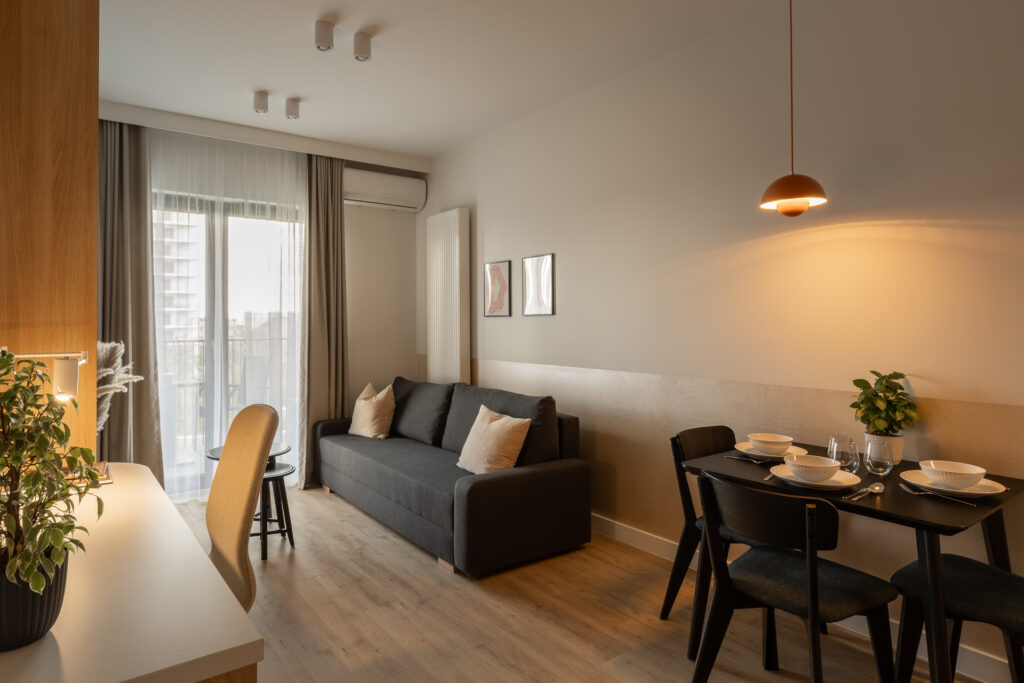Salon z miejscem do pracy zdalnej w apartamencie na podróż służbową.