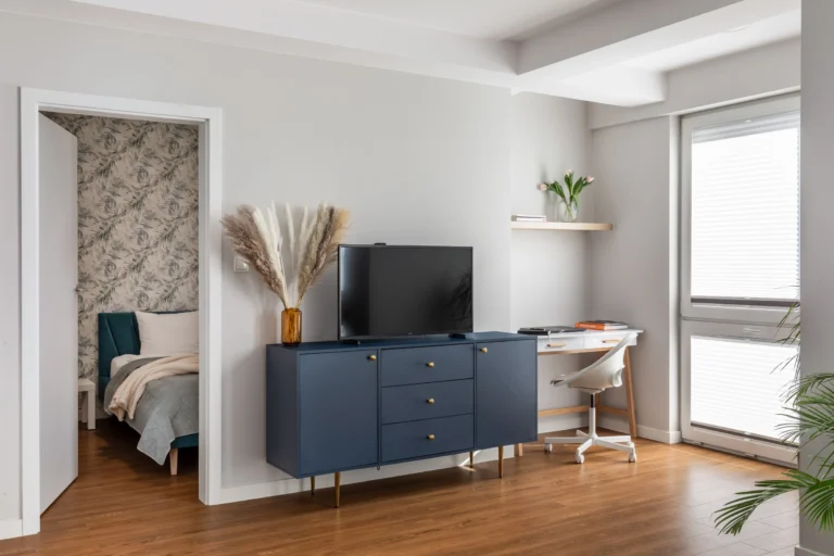 Salon z komodą, telewizorem i biurkiem w apartamencie na wynajem w Tychach